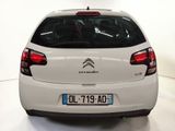 the rear end of a white citrole parked in a white room