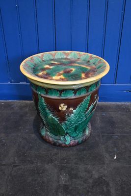une jardinière verte et marron posée par terre