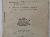 un vieux livre posé sur une table à côté d'un mur blanc