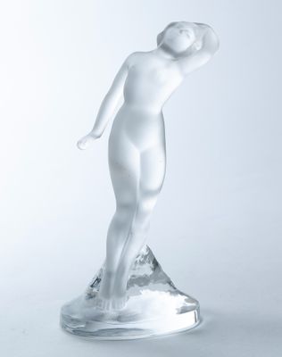 statue of a woman standing on a clear base with her hands on her head