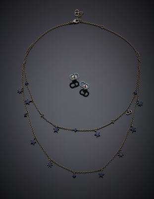 un gros plan d'un collier et de boucles d'oreilles sur fond noir