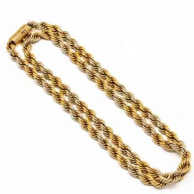 a close up of a gold rope necklace on a white background