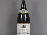 une bouteille de vin posée sur une table à côté d'un verre