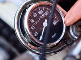 a close up of a person holding a speedometer on a motorcycle