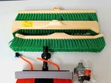 une photo représentant un balai et une brosse posés sur une table