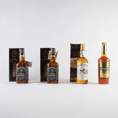trois bouteilles de whisky posées les unes à côté des autres sur une surface blanche