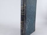 an old book sitting on top of a table next to a white wall