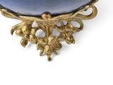 a blue bowl sitting on a gold stand on a white surface
