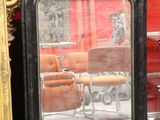 a mirror that is sitting on the floor next to a chair
