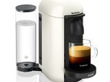une machine à café blanche avec une tasse de café à côté
