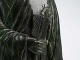 a statue of a man holding a comb in his hand