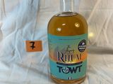 une bouteille de rhum posée sur un lit, avec une étiquette