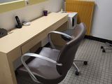 a desk with a chair and a mirror in a room