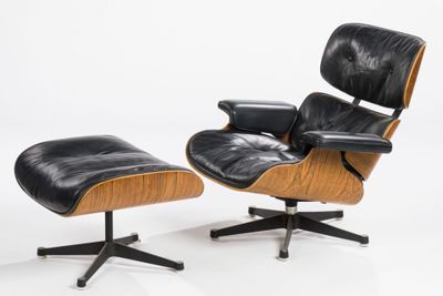 a black leather lounge chair and ottoman on a white background