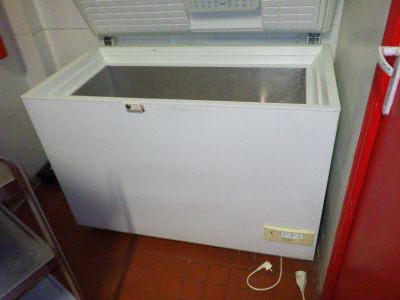 un congélateur coffre blanc posé dans le coin d'une pièce