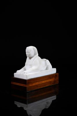 an image of a white statue of a lion on a wooden base