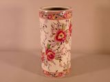 un vase blanc avec des fleurs roses sur une table