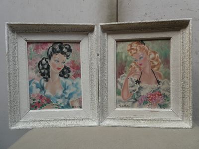 two framed pictures of a woman and a cat on a table