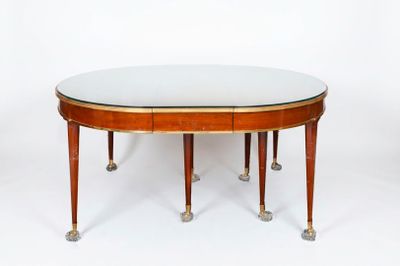 an oval dining table with a glass top and four legs