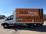a delivery truck parked in a parking lot with a sky background