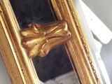 a mirror with a gold frame with a dog ' s head on it