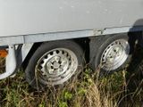a trailer that is parked in a field of tall grass
