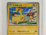 La carte Pokémon se trouve dans un étui en plastique posé sur une surface blanche.