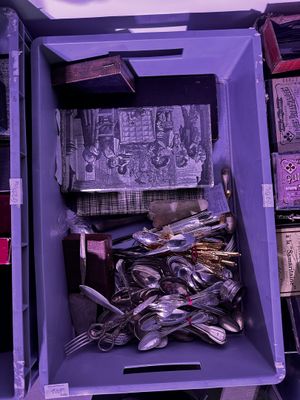 une boîte violette remplie de cuillères et de fourchettes en argent