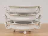 a stack of white dishes sitting on a wooden table