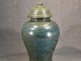 a blue vase with a lid sitting on a table