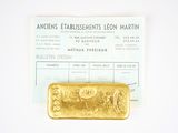 a gold bar sitting on top of a piece of paper