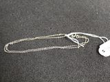 a white tag on a silver chain on a black surface