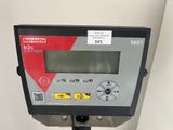 an image of a digital meter on a stand with a white wall behind it