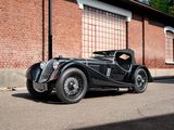 a black vintage car parked in front of a brick building