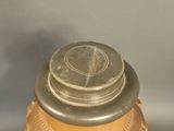 a gold vase with a silver lid on a table