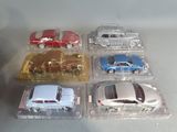 several toy cars are sitting in plastic boxes on a table