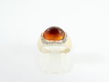 an image of a ring with a large orange stone on it