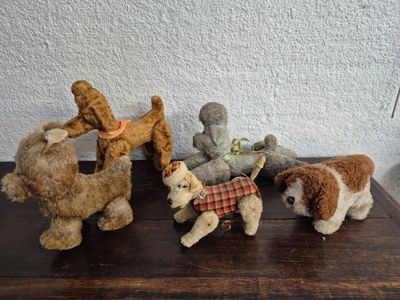 cinq peluches posées sur une table en bois