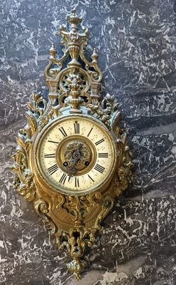 une horloge dorée accrochée au mur d'un immeuble