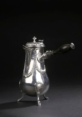 une cafetière ancienne en argent avec une anse, sur fond noir