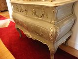 a dresser with a mirror on top of it in a room