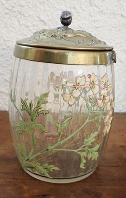 un bocal en verre orné de fleurs, posé sur une table