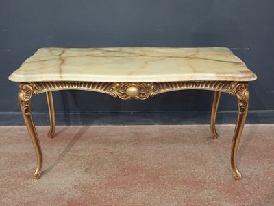 une image représentant une table avec un plateau en marbre et des pieds dorés