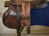 une selle marron avec une couverture bleue sur un support