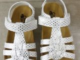 a close up of a pair of children ' s white sandals