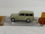 a green toy car on a clear plate with a yellow candle