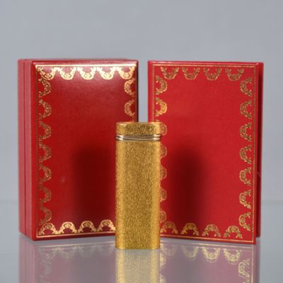 a red and gold box with a gold lighter in it