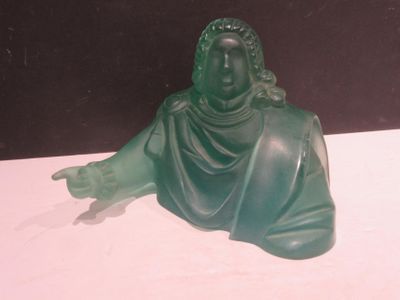 une statue verte représentant une femme assise sur une table