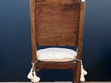 a wooden chair with a white cushion on it