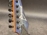 a close up of a guitar with a blue and orange neck